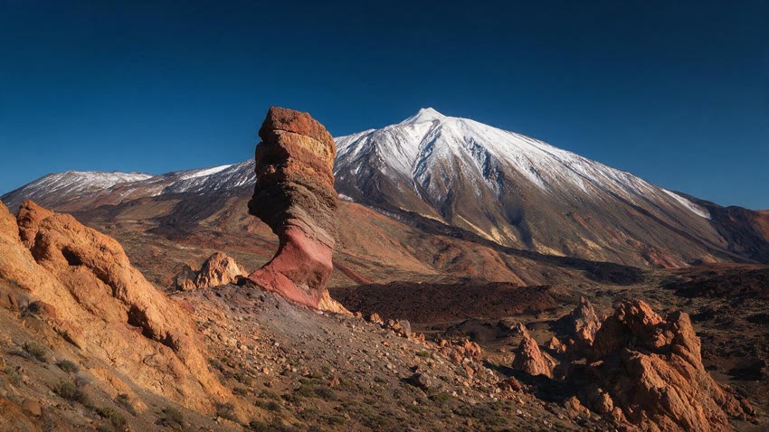 Le Teide enneigé derrière les roches ocre et rouges des Roques de García, dans le parc national