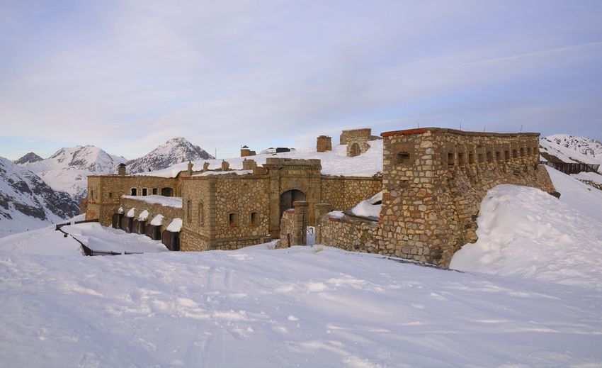 Fort de pierre enneigé sur les hauteurs de Montgenèvre, sommets au loin sous un ciel pâle