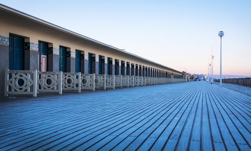 Les Planches de Deauville au petit matin : la promenade en bois et les cabines aux noms de stars de cinéma