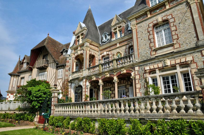 Une villa Belle Époque de Cabourg : façade de brique et de pierre, balcons sculptés, tourelle et colombages