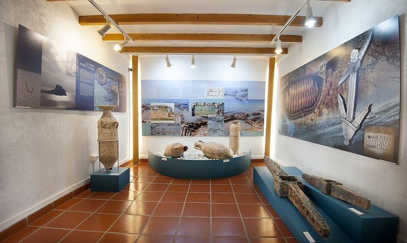 Salle du musée d'histoire de Calpe : amphores romaines, barque de bois ancienne et panneaux sur la pêche