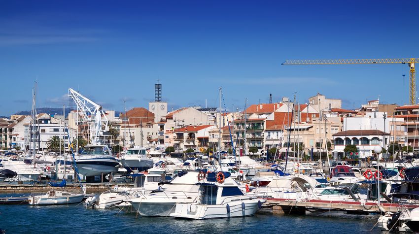 Bateaux de plaisance et de pêche dans le port de Cambrils, avec le clocher et les maisons du centre derrière