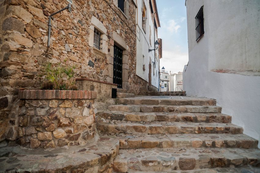 Ruelle pavée et maisons de pierre dans la vieille ville fortifiée de Tossa de Mar
