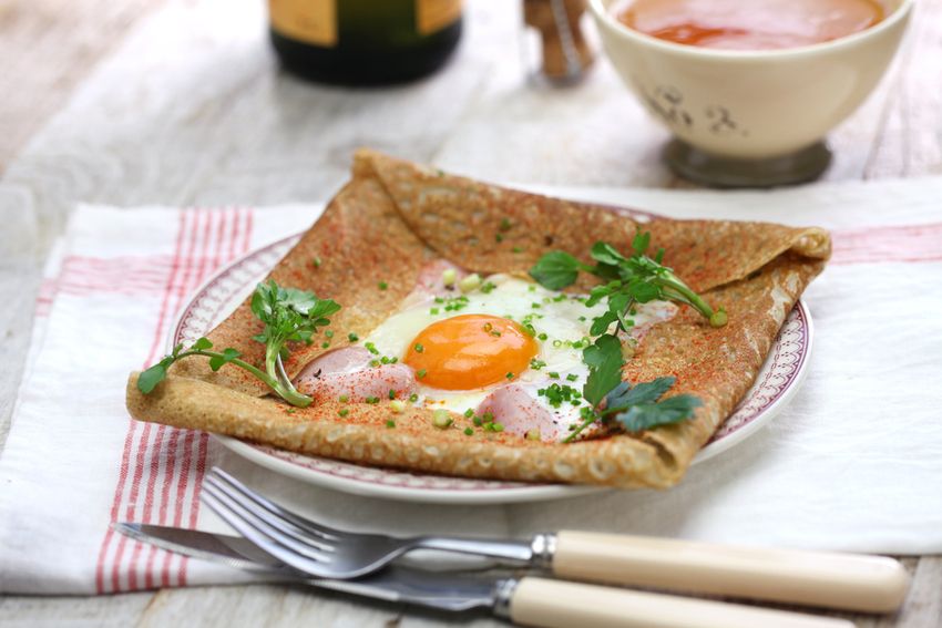 Galette de sarrasin complète, jambon et œuf au plat, servie pliée en carré sur une assiette