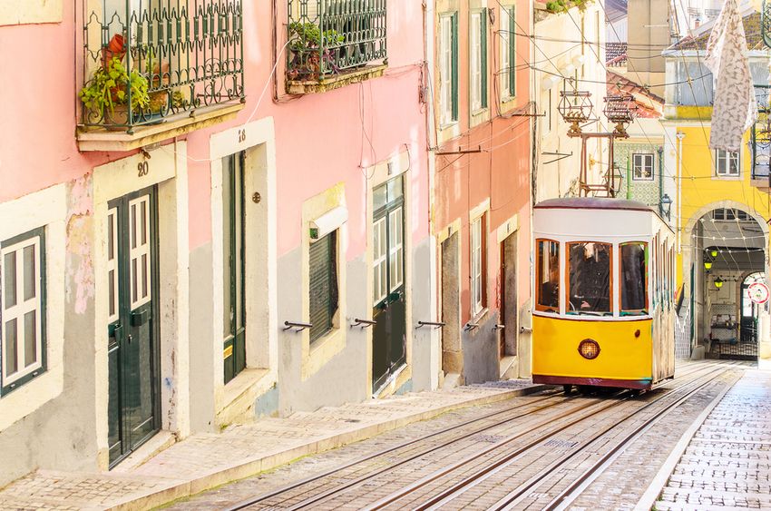Le funiculaire jaune de la Bica descend une ruelle pavée de Lisbonne, entre les façades roses et jaunes